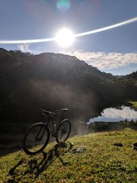 Bicycle parked against mountains on sunny day