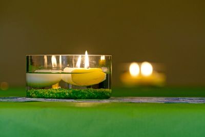 Close-up of illuminated candle on table