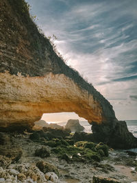 Rock formations by sea against sky