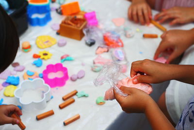 High angle view of people making clay craft at table