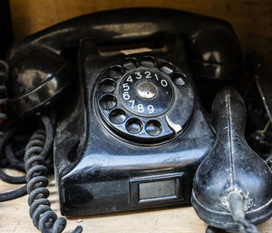 Close-up of old telephone booth on table