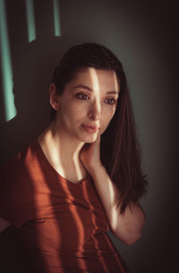 Beautiful woman standing by wall at home