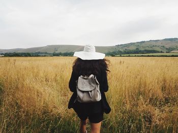 Rear view of woman standing on field