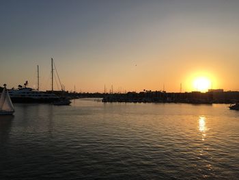 Boats in sea at sunset