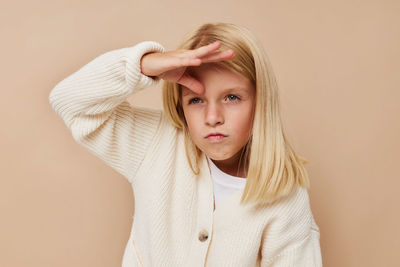 Portrait of young woman standing against wall