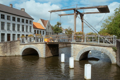 Arch bridge over river against sky