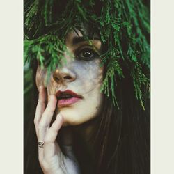 Close-up of thoughtful woman below branch