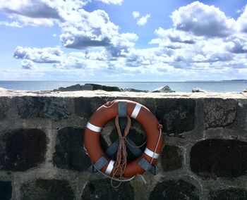Lifebuoy on beach against sky