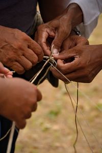 Cropped image of men tying string
