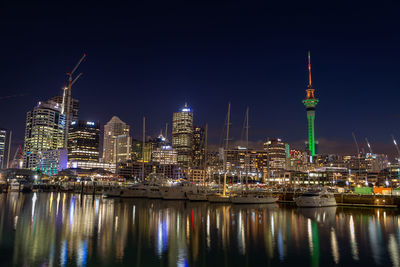 Illuminated city buildings by river at night