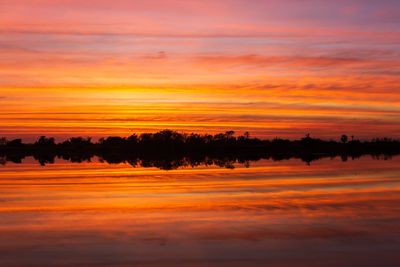 Scenic view of lake against orange sky