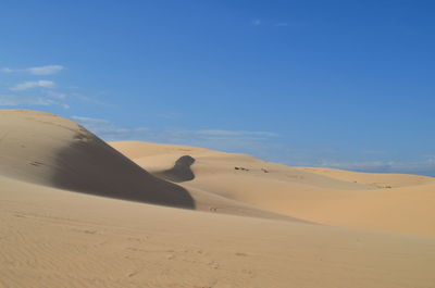 Scenic view of desert against blue sky