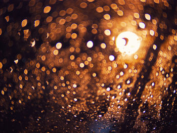 Full frame shot of raindrops on illuminated street lights