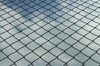 Full frame shot of chainlink fence against sky