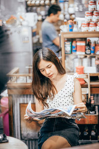 Young woman with arms raised standing in store