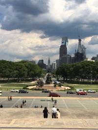 People on city against cloudy sky