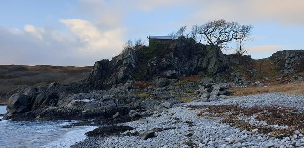 Rock formations by sea against sky