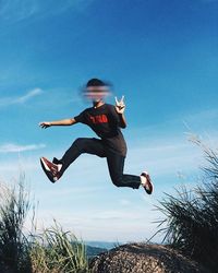 Rear view of woman jumping in mid-air