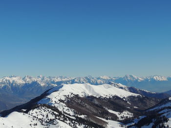 Scenic view of snowcapped mountains against clear blue sky