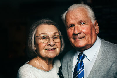 Close-up portrait of senior couple smiling in darkroom