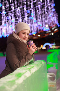 Night portrait of the girl in a winter city on ice rink