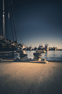 Sailboats moored in sea against clear sky