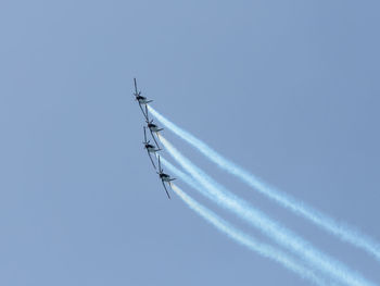 Low angle view of airshow against clear sky