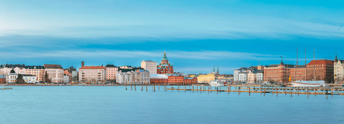 Buildings by river against sky