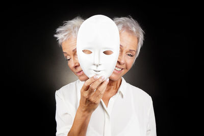 Close-up portrait of a woman against black background