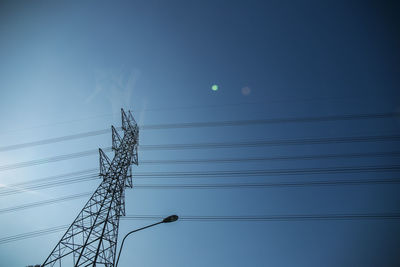 Low angle view of silhouette electricity pylon against sky