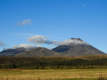 Scenic view of mountains against blue sky