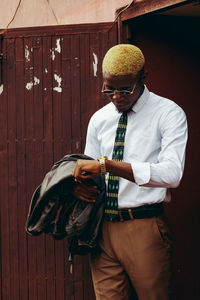 Young man with umbrella standing outdoors