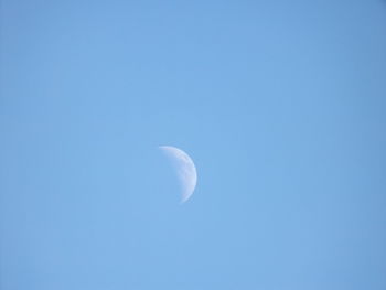 Low angle view of moon against blue sky