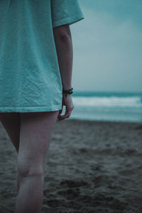 Midsection of woman standing on beach