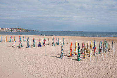 People at beach against sky