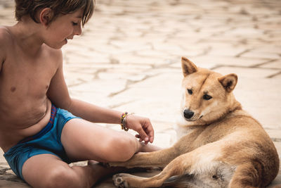 Midsection of woman with dog sitting outdoors