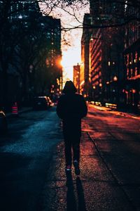 Rear view of man walking on road at night