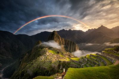 Scenic view of rainbow over mountains against sky