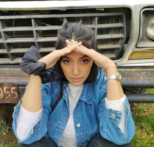 Portrait of a young woman sitting outdoors