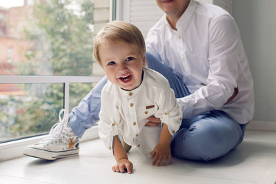 Father and son sitting by the window in the white room