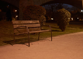Empty chairs and table in park at night