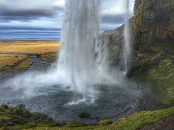 Waterfall at vestmannaeyjar against sky