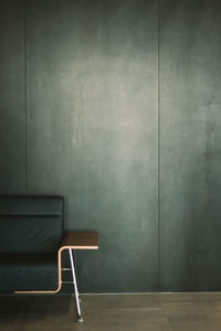 Empty chair against wall at home