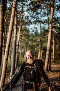 A portrait of a retired male hiker with a beard wearing a backpack