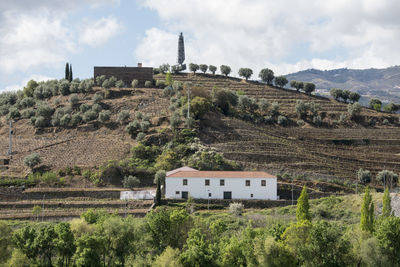 Built structure on field by mountain against sky