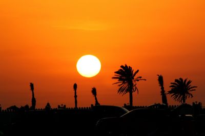 Silhouette palm trees against sky during sunset