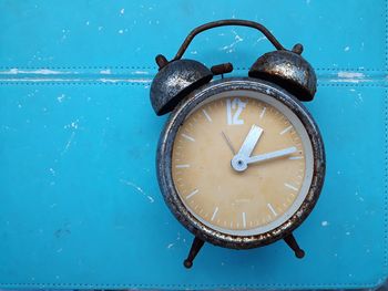 Directly above shot of weathered clock on blue table