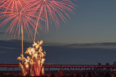 Firework display at night over bridge