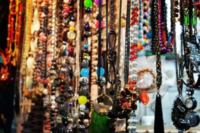 Close-up of various necklaces for sale at street market during night