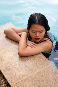 Portrait of asian woman looking in one side while is into the pool